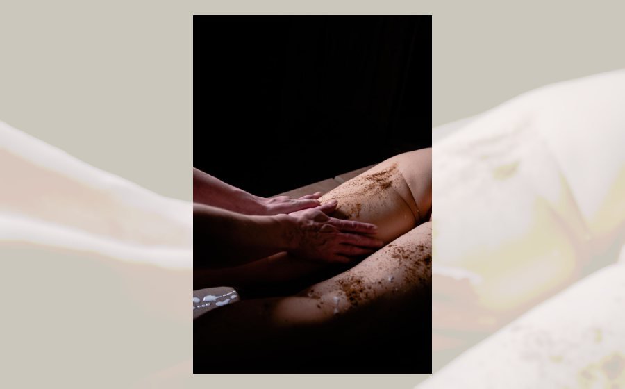 Tratamiento corporal exfoliante aplicado en piernas dentro de una cabina de spa