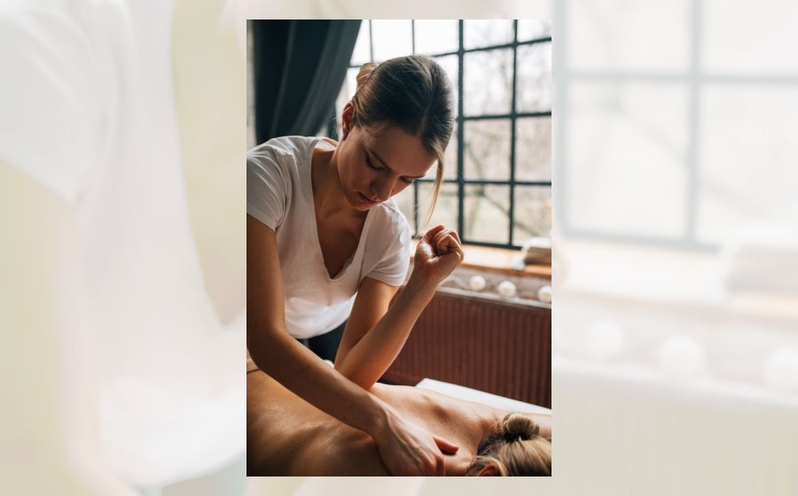 Profesional aplicando masaje descontracturante en cabina de spa